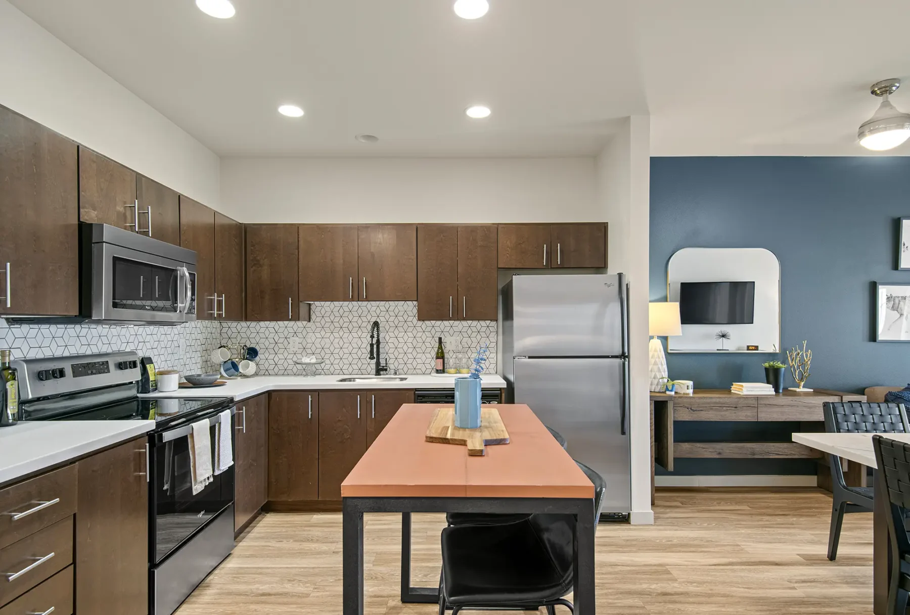 Kitchen with stainless steel appliances and brown cabinets at VUE25 apartments in Tacoma