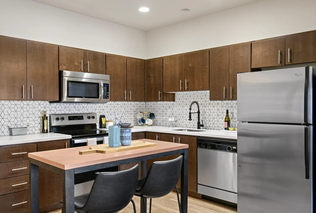 Kitchen with stainless steel appliances and brown cabinets at VUE25 apartments in Downtown Tacoma