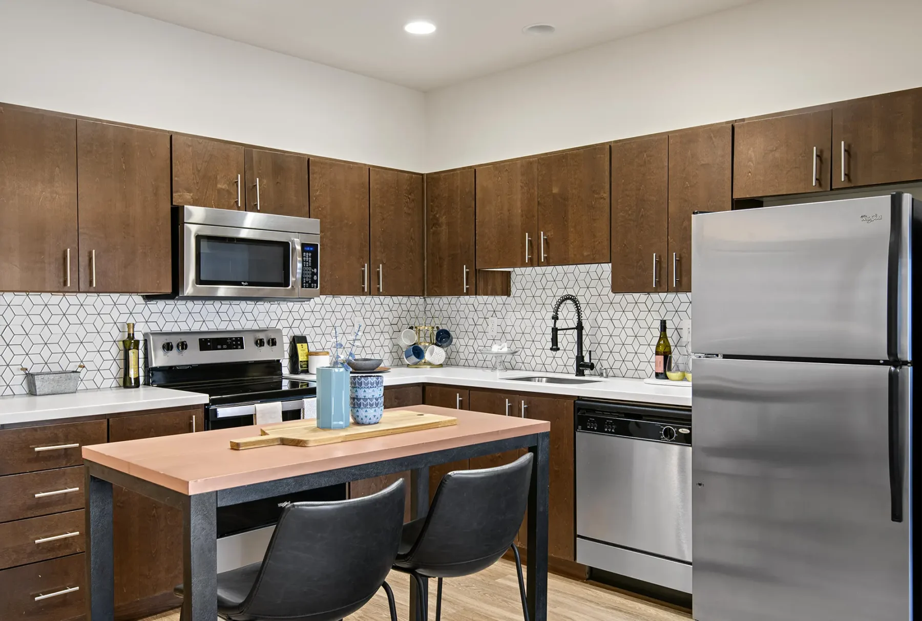 Kitchen with stainless steel appliances and brown cabinets at VUE25 apartments in Downtown Tacoma