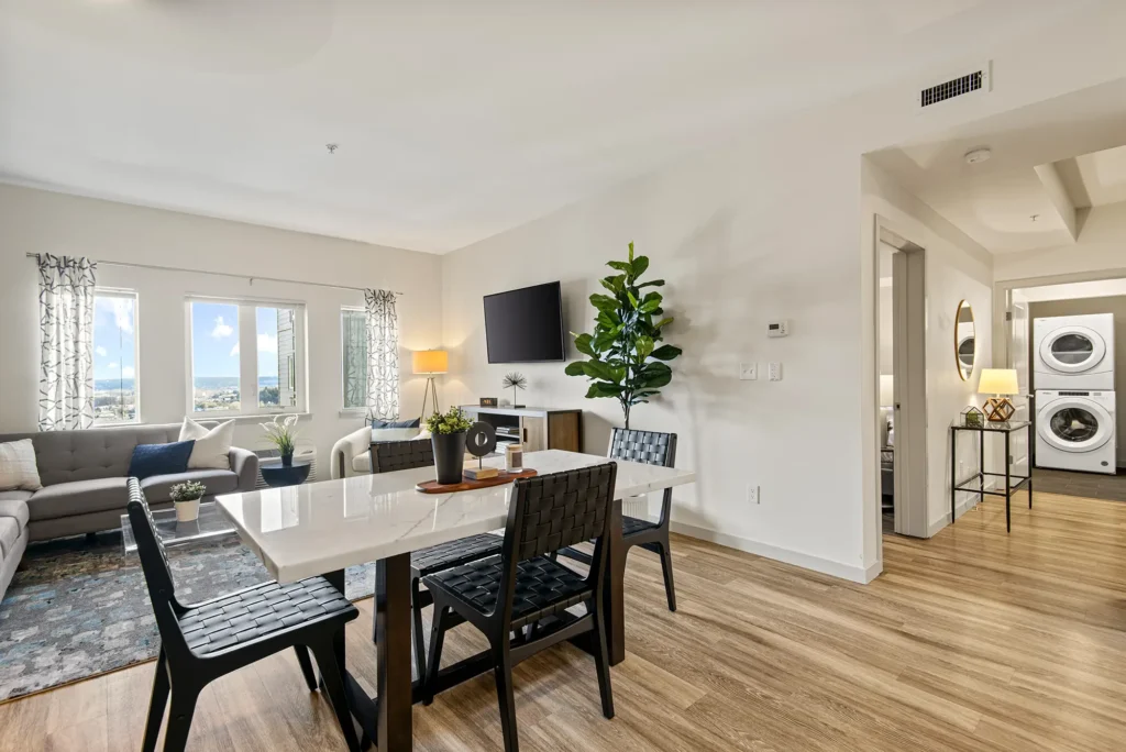 Staged dining room with view of living room and hallway